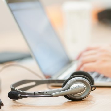 hand on laptop typing voip headphones phone system